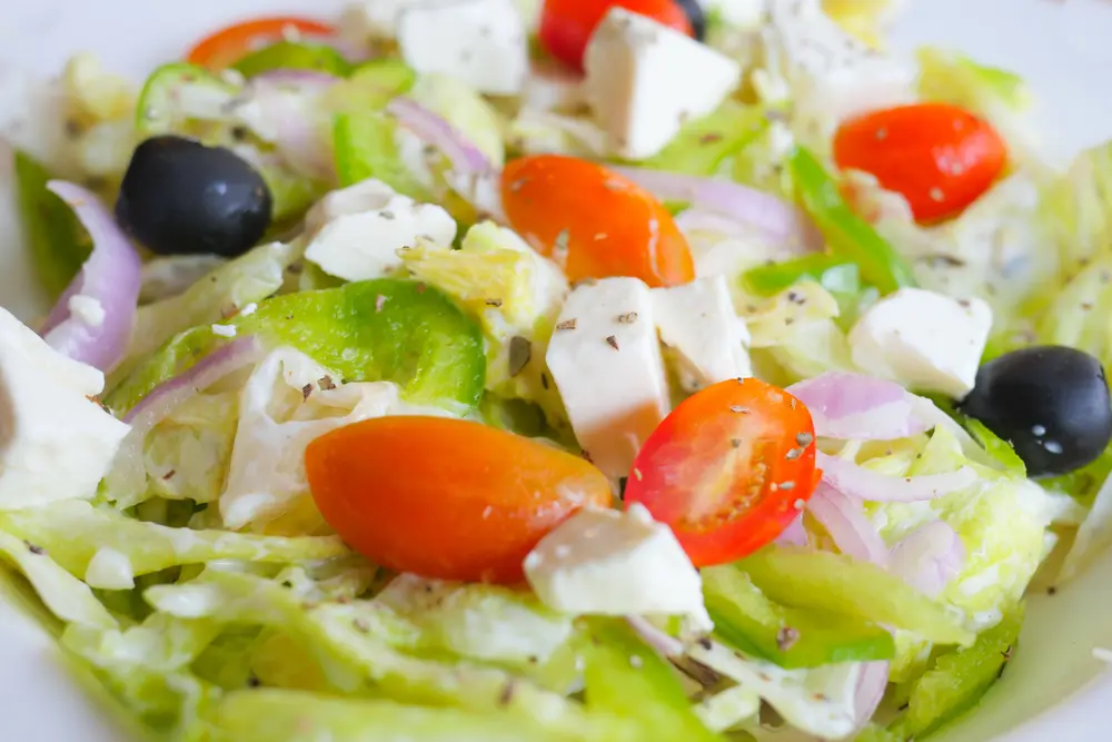 Illustrative Greek salad with tomato, feta cheese and olives